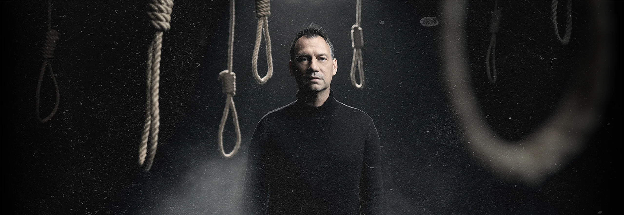 Sebastian Fitzek poses in front of dark ropes